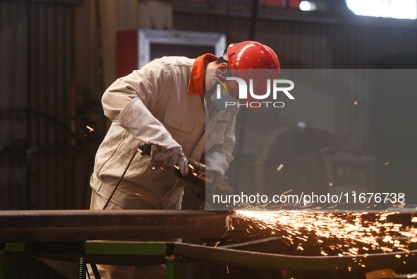 A worker polishes machinery parts for export at a machinery manufacturing workshop in Hangzhou, Zhejiang province, China, on October 18, 202...