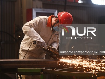 A worker polishes machinery parts for export at a machinery manufacturing workshop in Hangzhou, Zhejiang province, China, on October 18, 202...