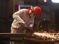 A worker polishes machinery parts for export at a machinery manufacturing workshop in Hangzhou, Zhejiang province, China, on October 18, 202...