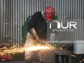 A worker polishes machinery parts for export at a machinery manufacturing workshop in Hangzhou, Zhejiang province, China, on October 18, 202...