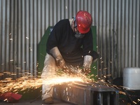 A worker polishes machinery parts for export at a machinery manufacturing workshop in Hangzhou, Zhejiang province, China, on October 18, 202...