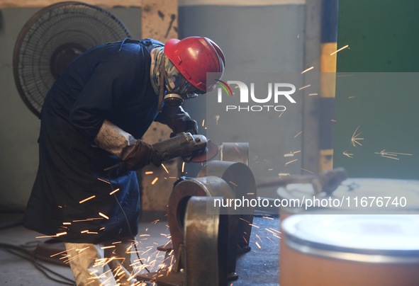 A worker welds machinery parts for export at a machinery manufacturing workshop in Hangzhou, Zhejiang province, China, on October 18, 2024....