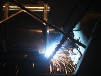 A worker welds machinery parts for export at a machinery manufacturing workshop in Hangzhou, Zhejiang province, China, on October 18, 2024....