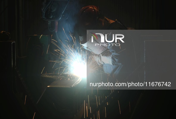 A worker welds machinery parts for export at a machinery manufacturing workshop in Hangzhou, Zhejiang province, China, on October 18, 2024....