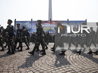 Thousands of armed forces and police personnel take part in a troop roll call at the National Monument in Jakarta, Indonesia, on October 18,...