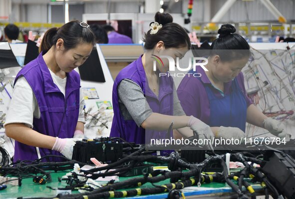 Workers rush to make products at an automobile wiring harness production line in Handan, China, on October 8, 2024. On October 8, 2024, the...