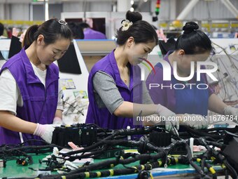 Workers rush to make products at an automobile wiring harness production line in Handan, China, on October 8, 2024. On October 8, 2024, the...