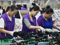 Workers rush to make products at an automobile wiring harness production line in Handan, China, on October 8, 2024. On October 8, 2024, the...