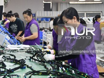 Workers rush to make products at an automobile wiring harness production line in Handan, China, on October 8, 2024. On October 8, 2024, the...