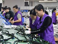 Workers rush to make products at an automobile wiring harness production line in Handan, China, on October 8, 2024. On October 8, 2024, the...