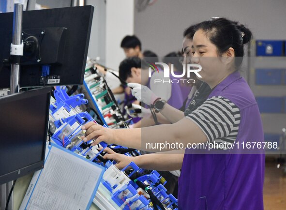 Workers rush to make products at an automobile wiring harness production line in Handan, China, on October 8, 2024. On October 8, 2024, the...