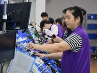 Workers rush to make products at an automobile wiring harness production line in Handan, China, on October 8, 2024. On October 8, 2024, the...