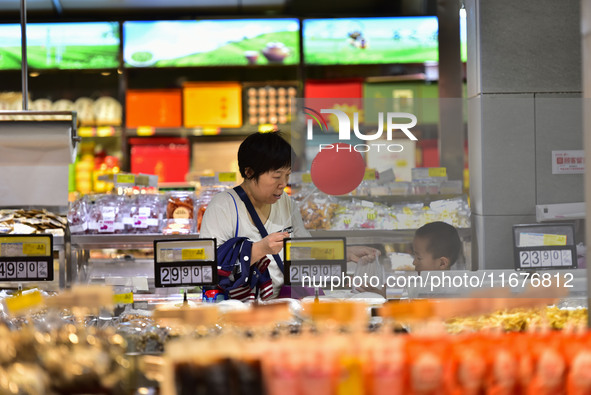 Consumers shop at a supermarket in Qingzhou, China, on October 13, 2024. On October 13, 2024, data released by the National Bureau of Statis...