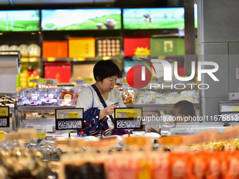 Consumers shop at a supermarket in Qingzhou, China, on October 13, 2024. On October 13, 2024, data released by the National Bureau of Statis...