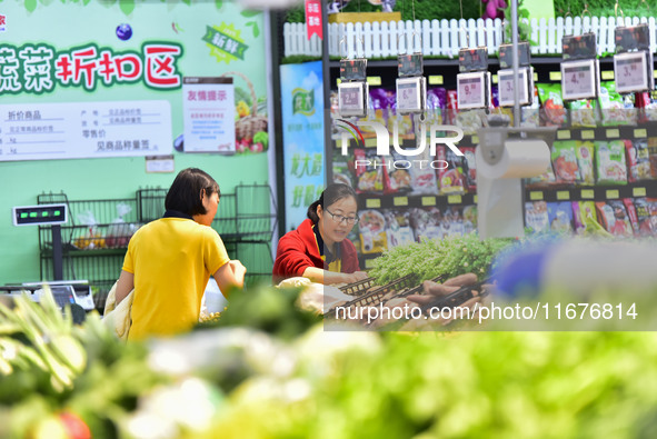 Consumers shop at a supermarket in Qingzhou, China, on October 13, 2024. On October 13, 2024, data released by the National Bureau of Statis...