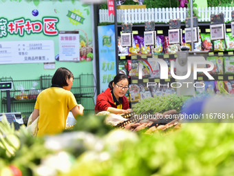 Consumers shop at a supermarket in Qingzhou, China, on October 13, 2024. On October 13, 2024, data released by the National Bureau of Statis...