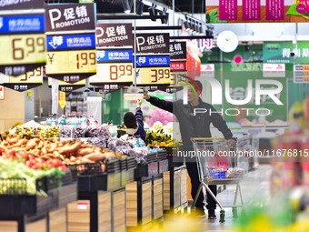 Consumers shop at a supermarket in Qingzhou, China, on October 13, 2024. On October 13, 2024, data released by the National Bureau of Statis...