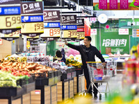 Consumers shop at a supermarket in Qingzhou, China, on October 13, 2024. On October 13, 2024, data released by the National Bureau of Statis...