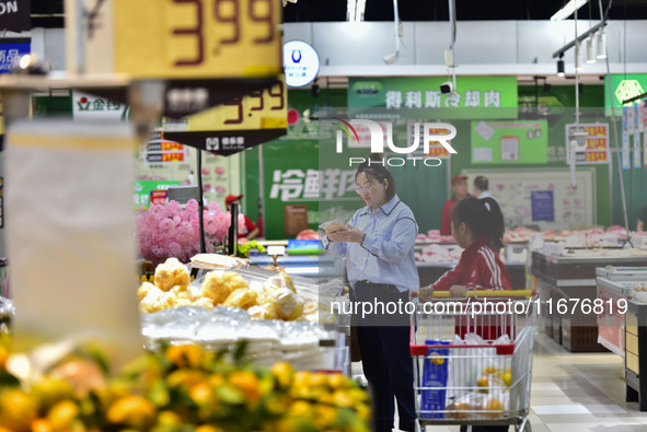 Consumers shop at a supermarket in Qingzhou, China, on October 13, 2024. On October 13, 2024, data released by the National Bureau of Statis...