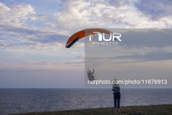 A paraglider flies over the Baltic Sea in Kaseberga, near Ystad, Scane, Sweden, on August 3, 2024. Ales Stenar, also called Swedish Stonehen...