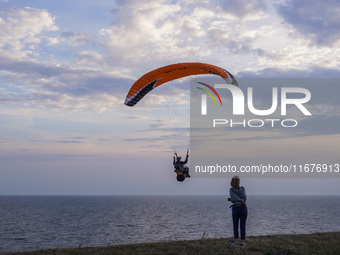 A paraglider flies over the Baltic Sea in Kaseberga, near Ystad, Scane, Sweden, on August 3, 2024. Ales Stenar, also called Swedish Stonehen...