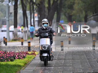 In Shenyang, China, on October 18, 2024, people change into thick clothes to travel after the rain. (