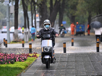 In Shenyang, China, on October 18, 2024, people change into thick clothes to travel after the rain. (