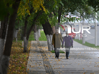 In Shenyang, China, on October 18, 2024, people change into thick clothes to travel after the rain. (