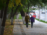 In Shenyang, China, on October 18, 2024, people change into thick clothes to travel after the rain. (