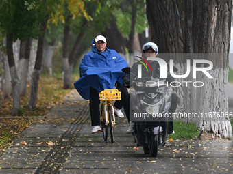 In Shenyang, China, on October 18, 2024, people change into thick clothes to travel after the rain. (