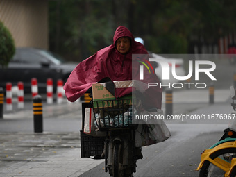 In Shenyang, China, on October 18, 2024, people change into thick clothes to travel after the rain. (