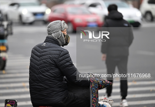 In Shenyang, China, on October 18, 2024, people change into thick clothes to travel after the rain. 