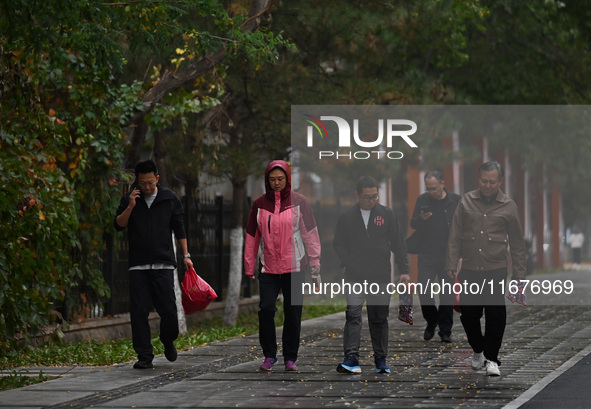 In Shenyang, China, on October 18, 2024, people change into thick clothes to travel after the rain. 