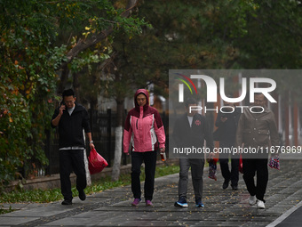 In Shenyang, China, on October 18, 2024, people change into thick clothes to travel after the rain. (