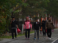 In Shenyang, China, on October 18, 2024, people change into thick clothes to travel after the rain. (