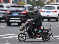 In Shenyang, China, on October 18, 2024, people change into thick clothes to travel after the rain. (