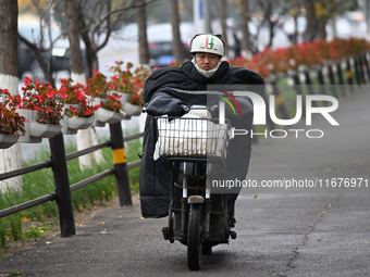 In Shenyang, China, on October 18, 2024, people change into thick clothes to travel after the rain. (