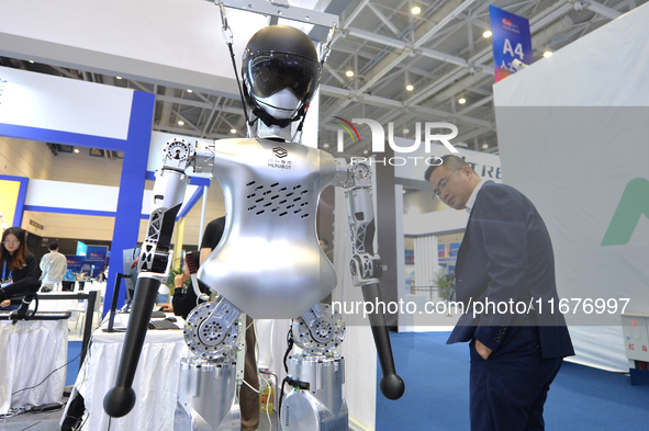 Visitors look at a humanoid robot at the 2024 China International Consumer Electronics Expo in Qingdao, China, on October 18, 2024. 