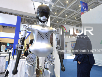 Visitors look at a humanoid robot at the 2024 China International Consumer Electronics Expo in Qingdao, China, on October 18, 2024. (