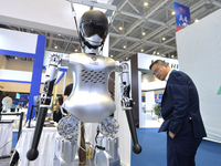 Visitors look at a humanoid robot at the 2024 China International Consumer Electronics Expo in Qingdao, China, on October 18, 2024. (