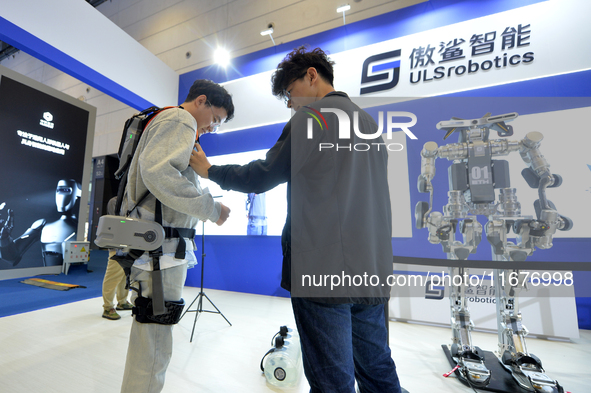 An audience experiences an intelligent electric upper limb exoskeleton robot at the 2024 China International Consumer Electronics Expo in Qi...