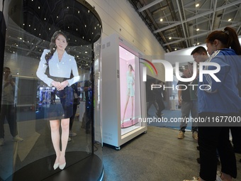 Visitors look at an AI holographic transparent capsule at the 2024 China International Consumer Electronics Expo in Qingdao, China, on Octob...