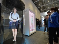 Visitors look at an AI holographic transparent capsule at the 2024 China International Consumer Electronics Expo in Qingdao, China, on Octob...