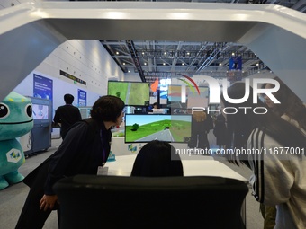 Visitors experience an intelligent driving simulation system at the 2024 China International Consumer Electronics Expo in Qingdao, China, on...