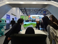 Visitors experience an intelligent driving simulation system at the 2024 China International Consumer Electronics Expo in Qingdao, China, on...