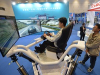 Visitors experience a three-screen six-axis racing demonstration system at the 2024 China International Consumer Electronics Expo in Qingdao...