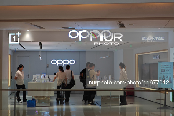 Customers experience mobile phones at an OPPO store in Shanghai, China, on October 18, 2024. 