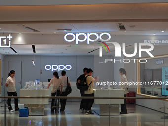 Customers experience mobile phones at an OPPO store in Shanghai, China, on October 18, 2024. (