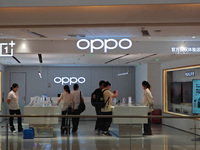 Customers experience mobile phones at an OPPO store in Shanghai, China, on October 18, 2024. (