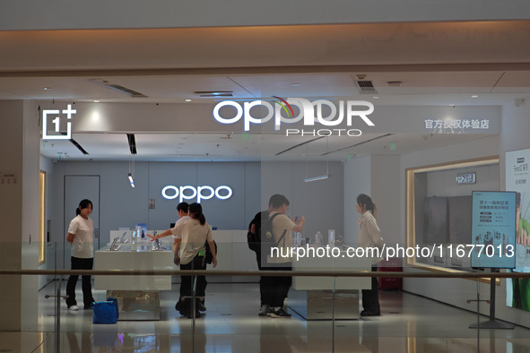 Customers experience mobile phones at an OPPO store in Shanghai, China, on October 18, 2024. 